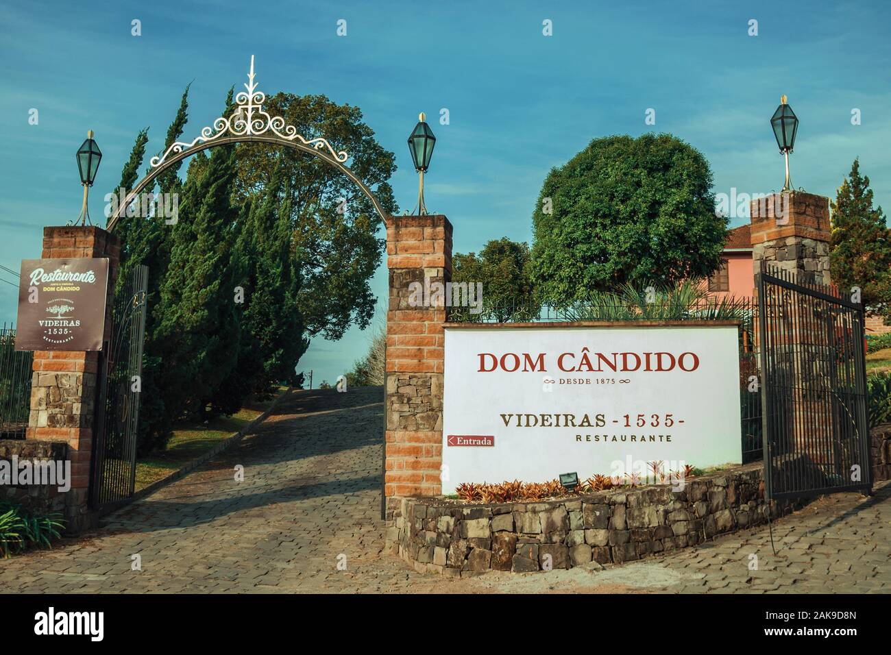 Iron gate open and wall with the company sign of Dom Candido Winery