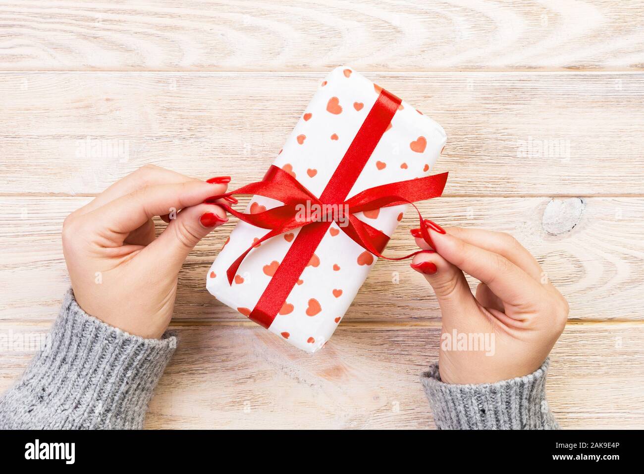 Woman Hands Give Wrapped Valentine Or Other Holiday Handmade Present In Paper With Red Ribbon Present Box Red Heart Decoration Of Gift On Wooden Tab Stock Photo Alamy