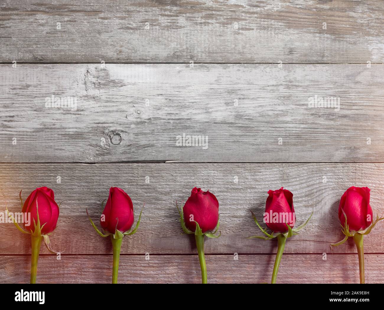 Five red roses on the old table. Valentine's Day background Stock Photo ...