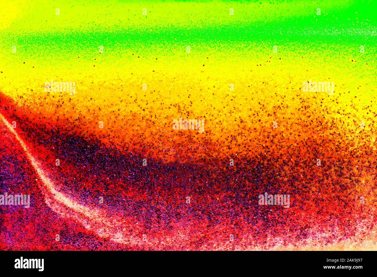 Colorful sand pigments falling down in water. Abstract background. Stock Photo