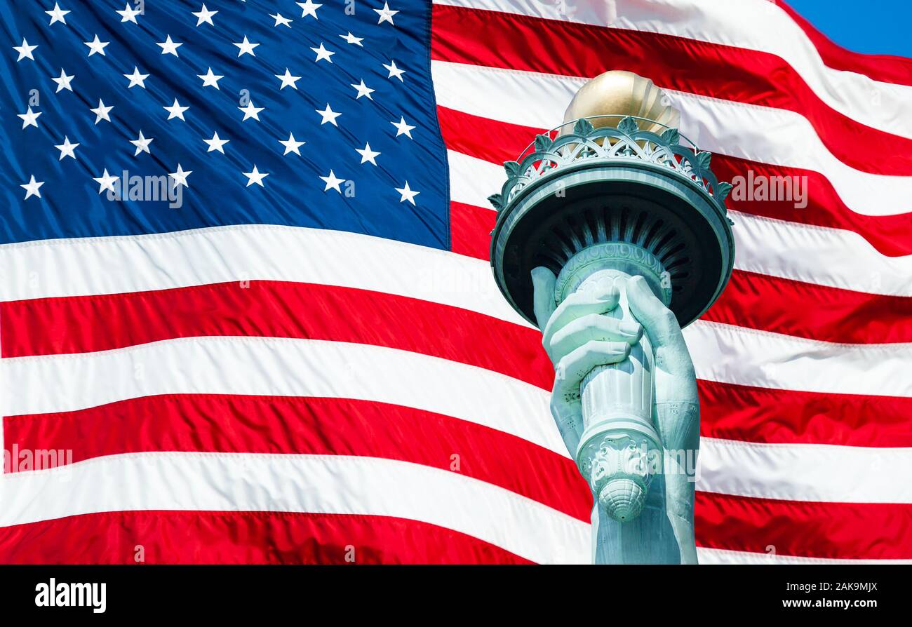 Statue of Liberty torch at New York City and US Flag waving on background Stock Photo