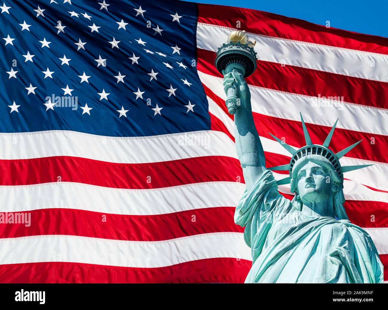 Statue of Liberty at New York City and US Flag Stock Photo