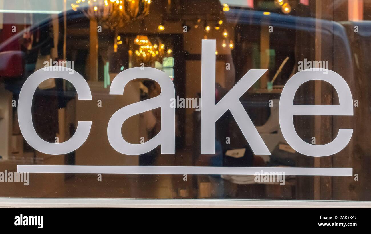 Pano frame Close up of a white cake sign on the shiny glass window of a store building Stock Photo