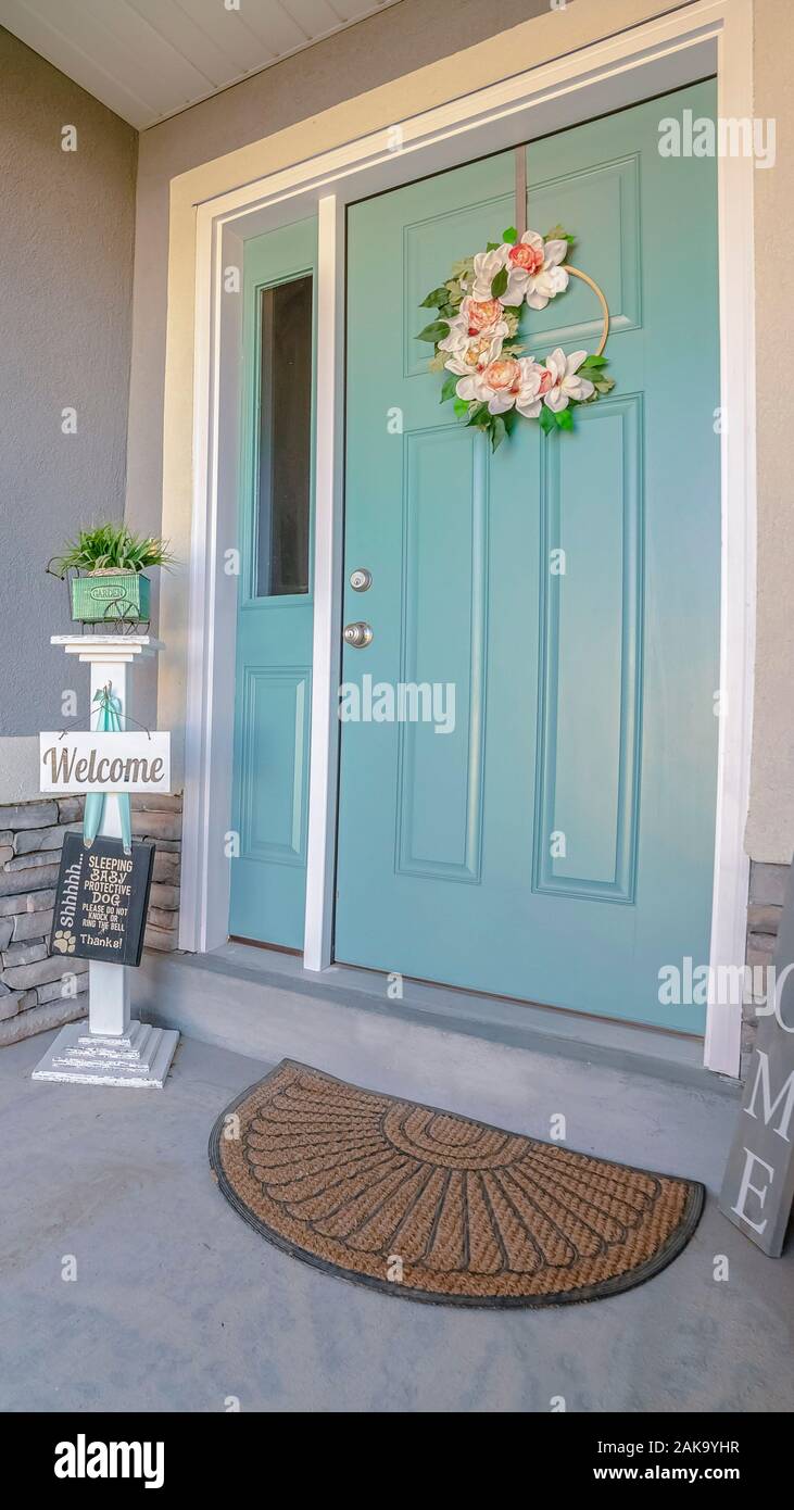 Vertical Frame Welcome Signs Alongside A Green Front Door Stock