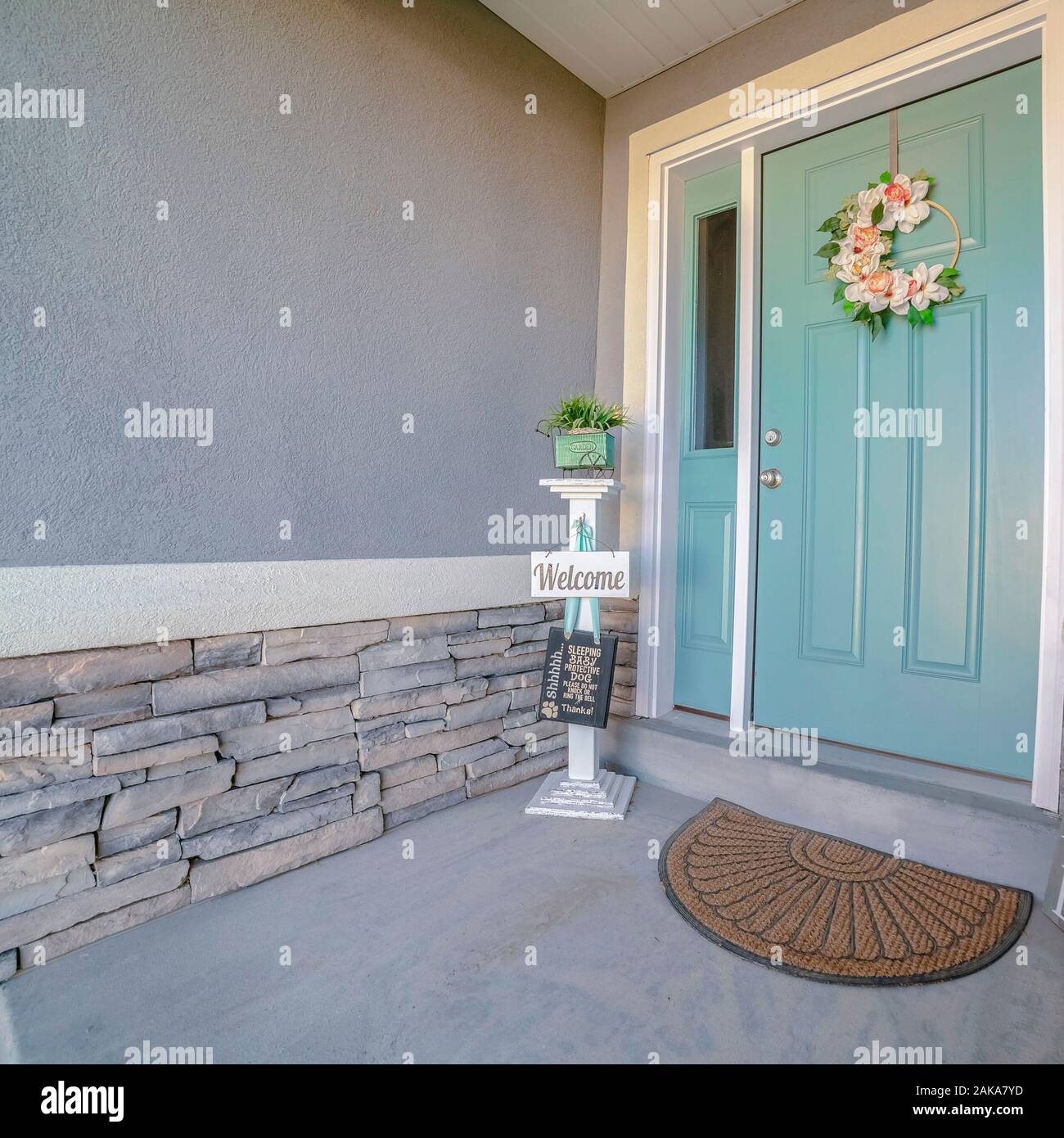 Square Frame Welcome Signs Alongside A Green Front Door Stock