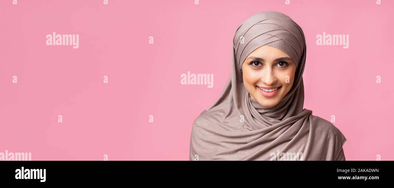 Portrait of confident muslim woman in hijab smiling and looking at ...