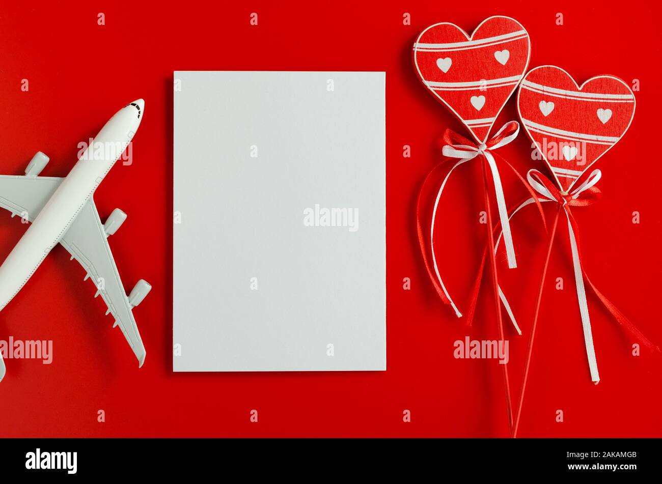 Travel planning on Valentines day . Travel concept, mockup. Blank white  paper, wooden hearts and model of passenger plane on red background. Top  view Stock Photo - Alamy