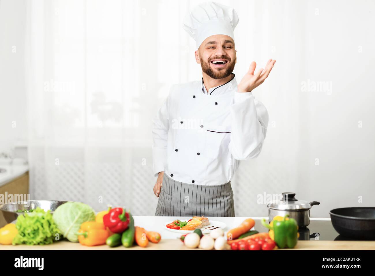 Perfect Taste. Professional Chef Man Gesturing With Hand Approving Recipe Smiling At Camera Standing In Kitchen. Selective Focus Stock Photo