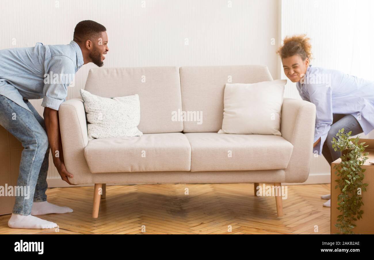Moving House African American Spouses Lifting Heavy Couch
