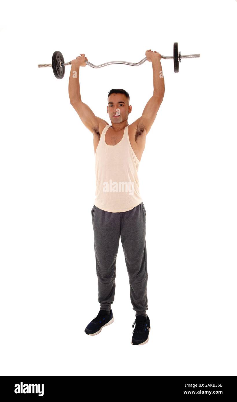 A tall young man standing in the studio in exercise outfit lifting some weight over his head, isolated for white background Stock Photo