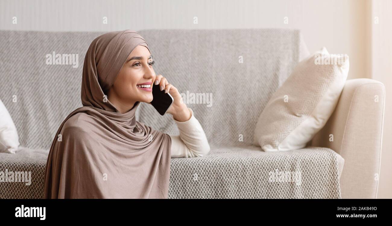Modern Muslim Woman In Hijab Talking On Mobile Phone At Home, Having ...