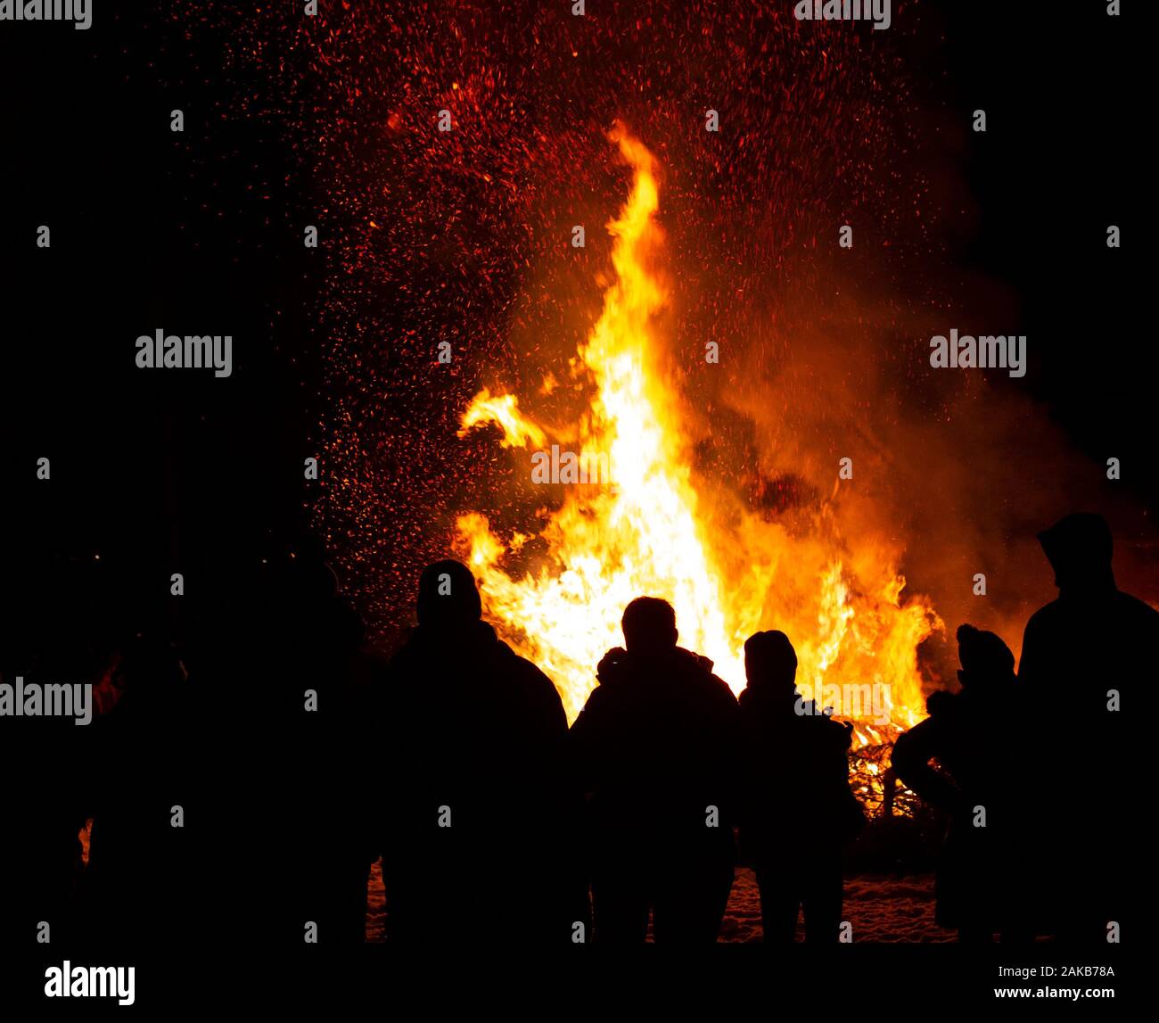 burning evergreen trees produce tall yellow and orange flames, and