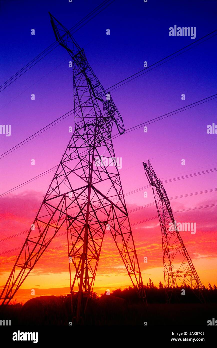 Low angle view of electricity pylon silhouettes at sunset, Edmonton, Alberta, Canada Stock Photo