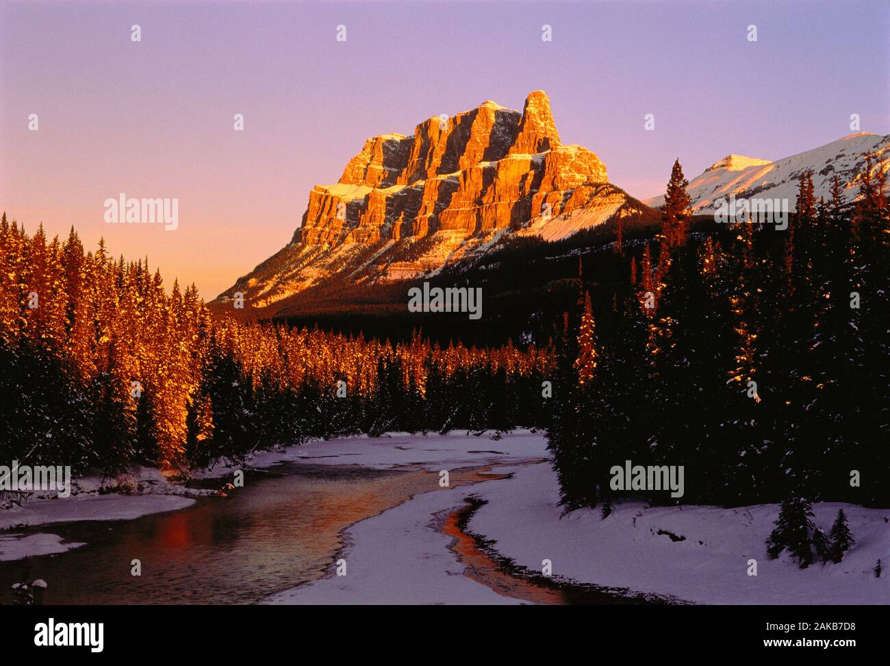 Landscape with Castle Mountain, river and forest in winter at sunset, Banff National Park, Alberta, Canada Stock Photo
