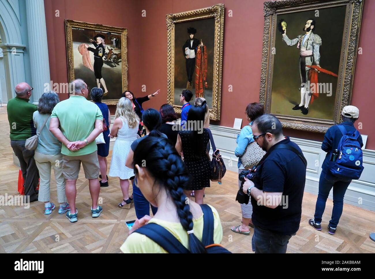 New York City, NY USA. Jul 2017. Asian American tour guide giving a group of visitors an educational briefing on some of the exotic paintings at The M Stock Photo
