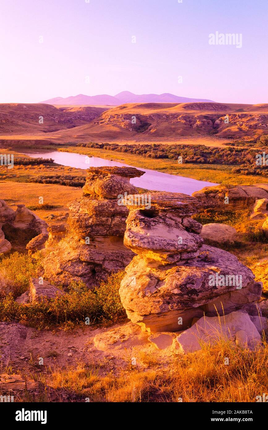 Landscape with rock formations and river at sunset, Writing on Stone Provincial Park, Alberta, Canada Stock Photo