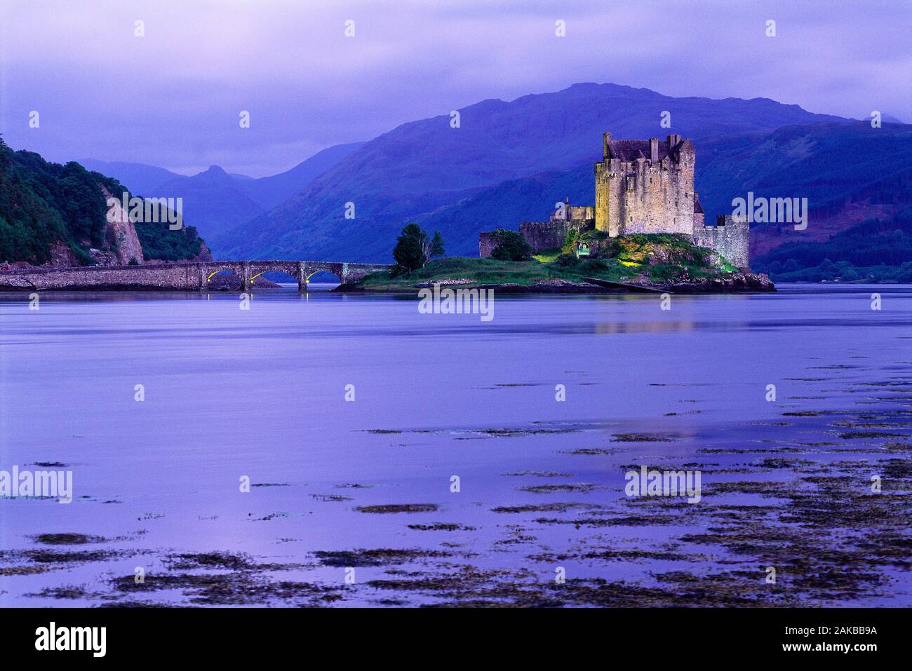 Eilean Donan Castle on island in lake and bridge at dusk, Highlands, Scotland, UK Stock Photo