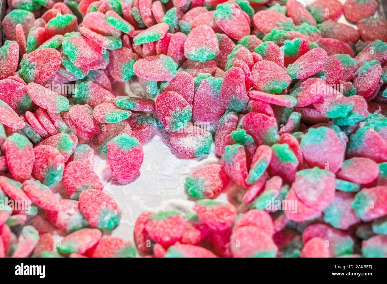 Selective focus, sugar coated giant strawberries soft jelly sweet on display at the Christmas market in Winter Wonderland of London Stock Photo