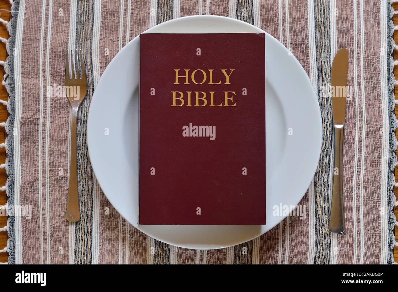 Bible on a dinner plate with silverware in lent Stock Photo