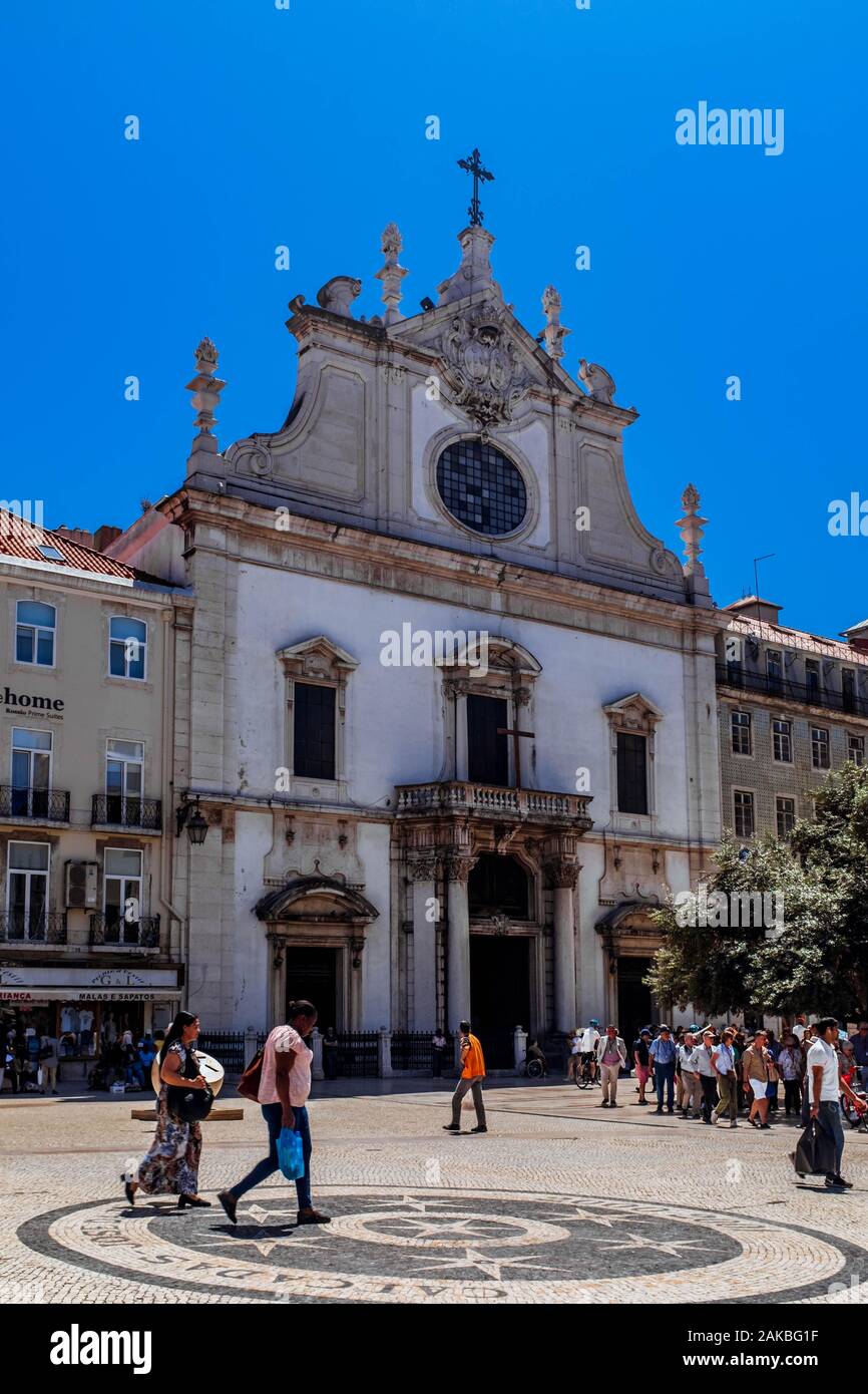 Locals and tourists walking by Igreja de São Domingos on a sunny spring day. Stock Photo