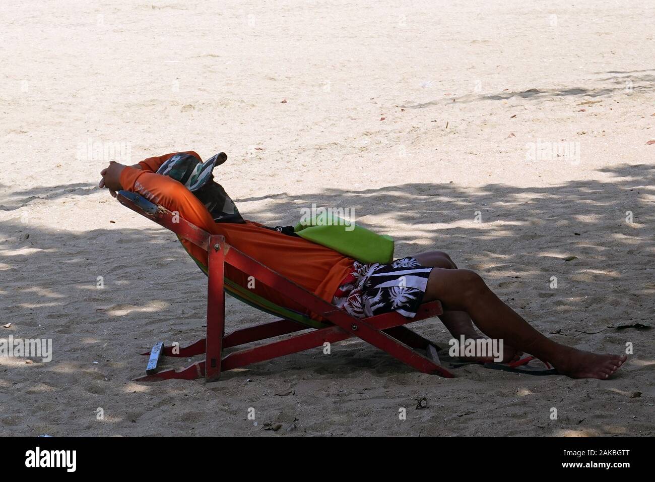 Man resting on chair on Pattaya Beach, Pattaya, Thailand. Stock Photo