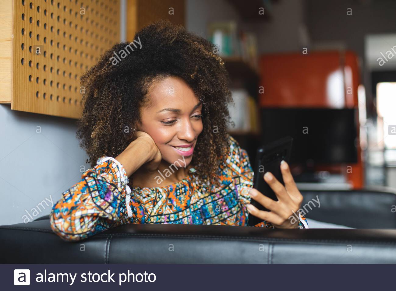 Casual Young Black Woman Relaxing At Home Using Smartphone Home