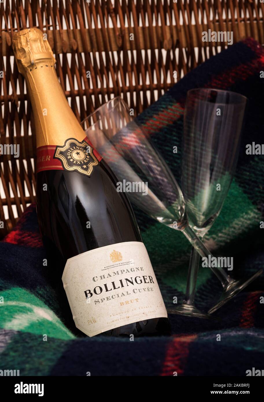 An unopened bottle of Bollinger Champagne with a couple of flute glasses. Royal Warrant that'll be removed following Queen's death. Stock Photo