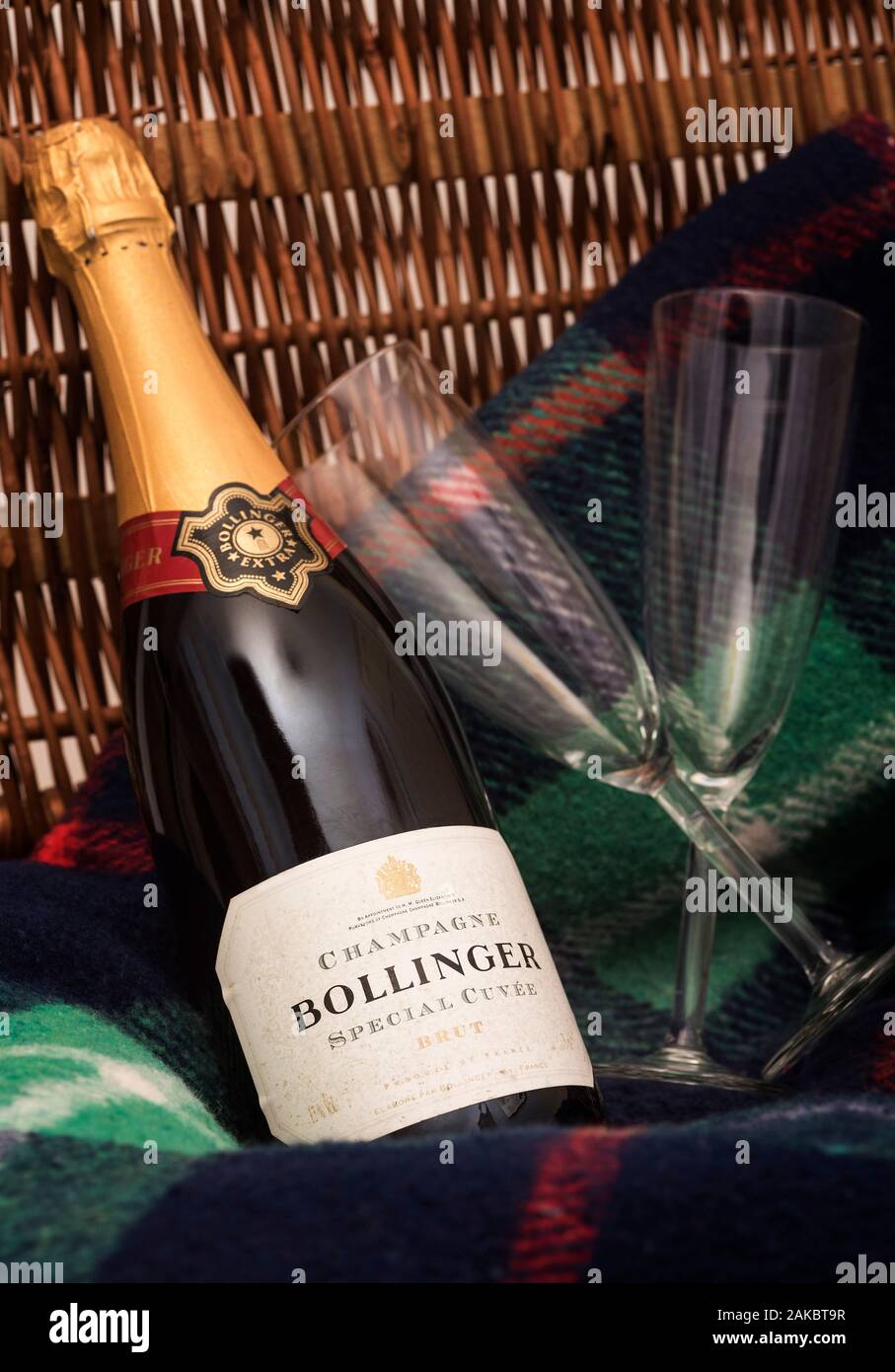 An unopened bottle of Bollinger Champagne with a couple of flute glasses. Royal Warrant that'll be removed following Queen's death. Stock Photo