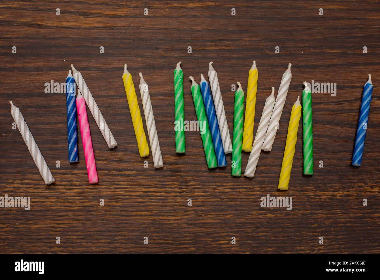 Close-up of colorful birthday cake candles on the background of an old wooden table Stock Photo