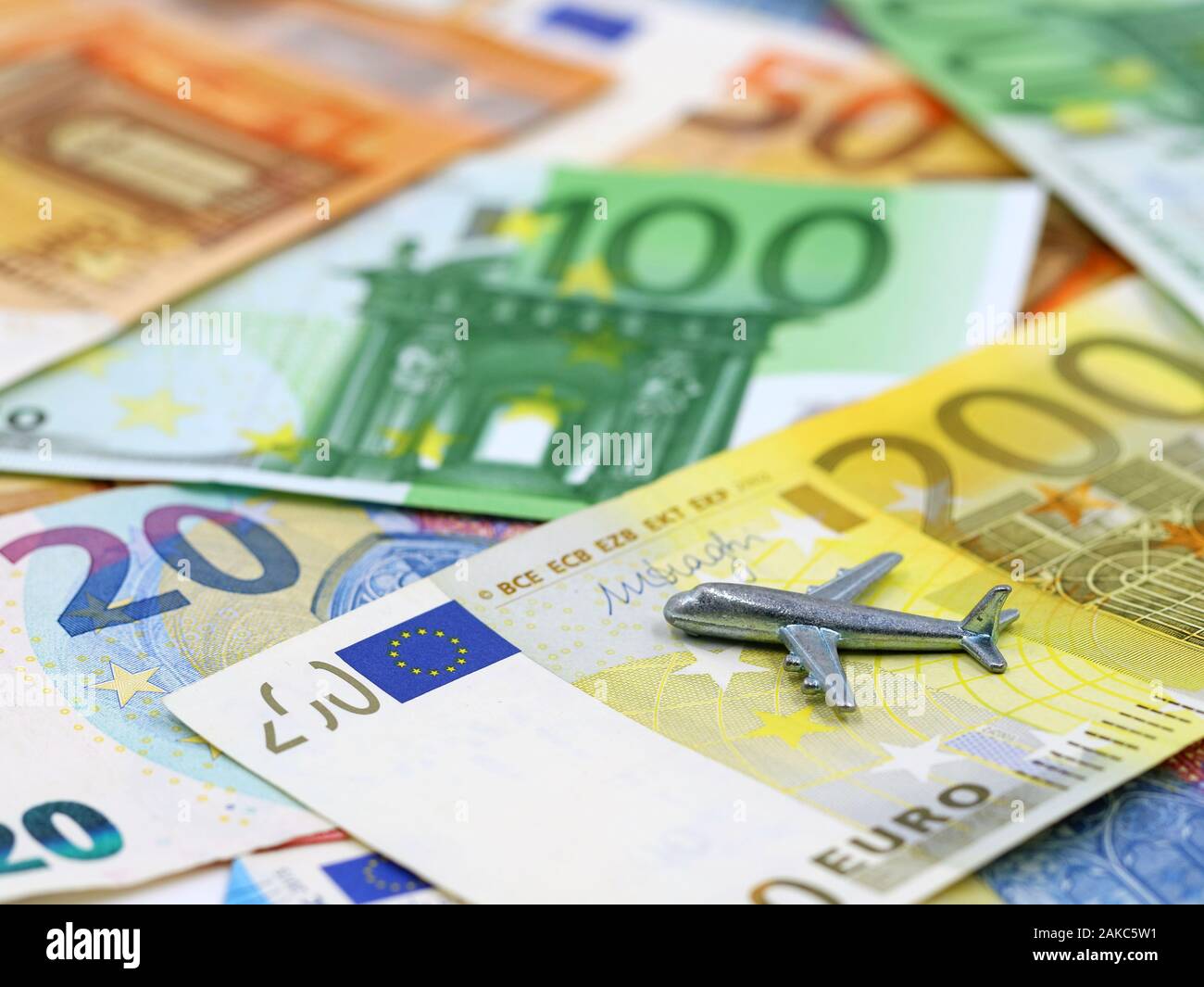 silver miniature airplane on various euro banknotes with copy space Stock Photo