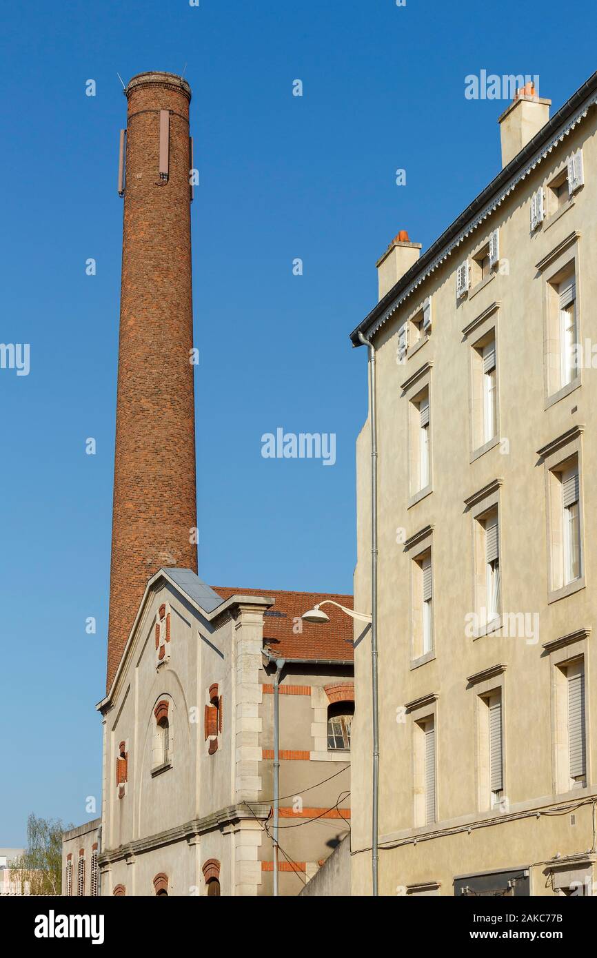 France, Meurthe et Moselle, Nancy, facade of an apartment building and red bricks chimney of a former industrial building in Rue Charles III (Charles the Thrid street) Stock Photo