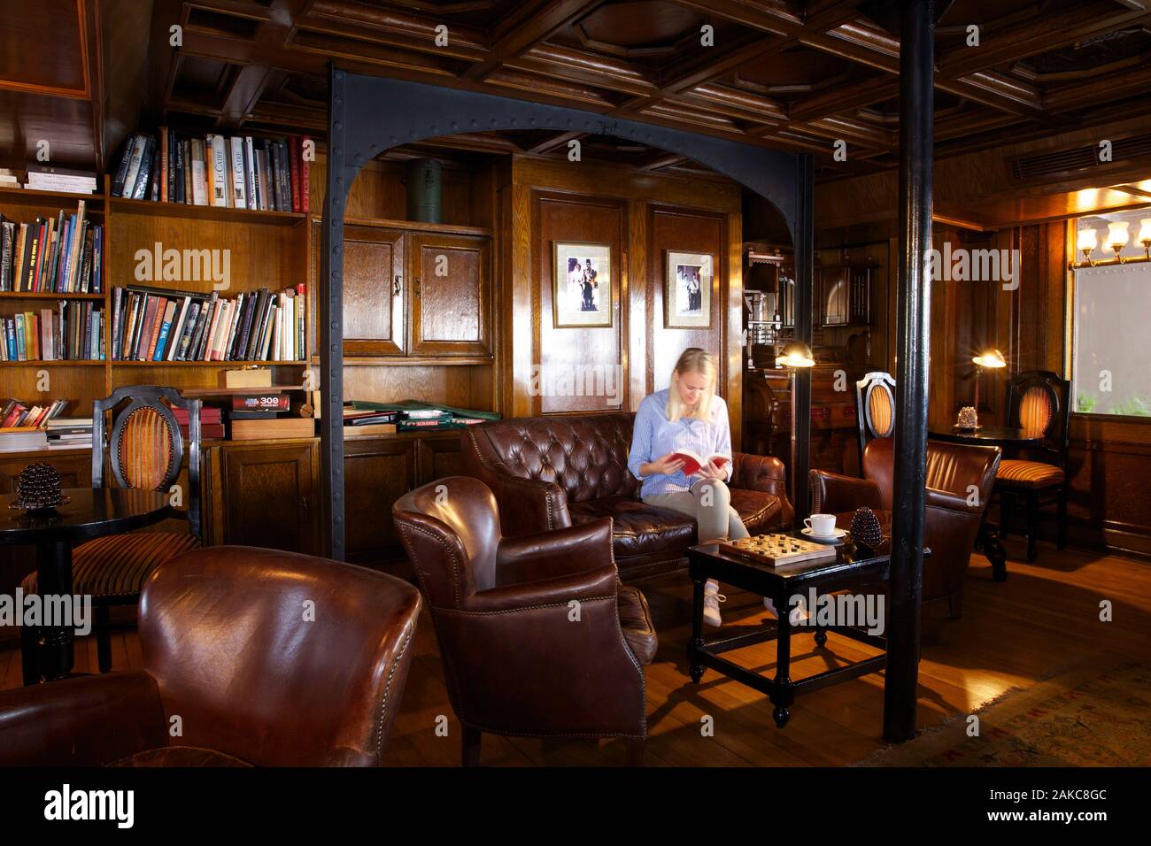 Egypt, Upper Egypt, Nile Valley, tourist sitting in a chesterfield sofa in the British style lounge of Steam Ship Sudan, the last steamboat on the Nile Stock Photo