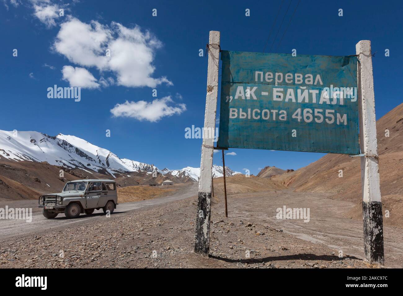 Tajikistan, Gorno-Badakhshan Autonomous Region, Ak-Baital Pass, altitude 4655m, Pamir Highway, Tajik National Park and Pamir Mountains, UNESCO World Heritage Site, track, jeep and Cyrillic sign announcing the altitude of the pass Stock Photo