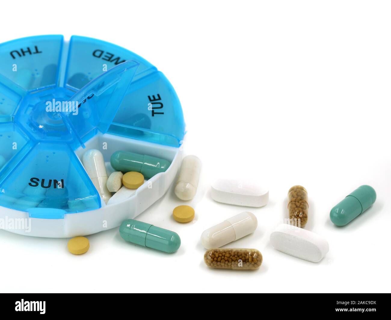 Close up of various pills in daily pill box on white background with copy space Stock Photo