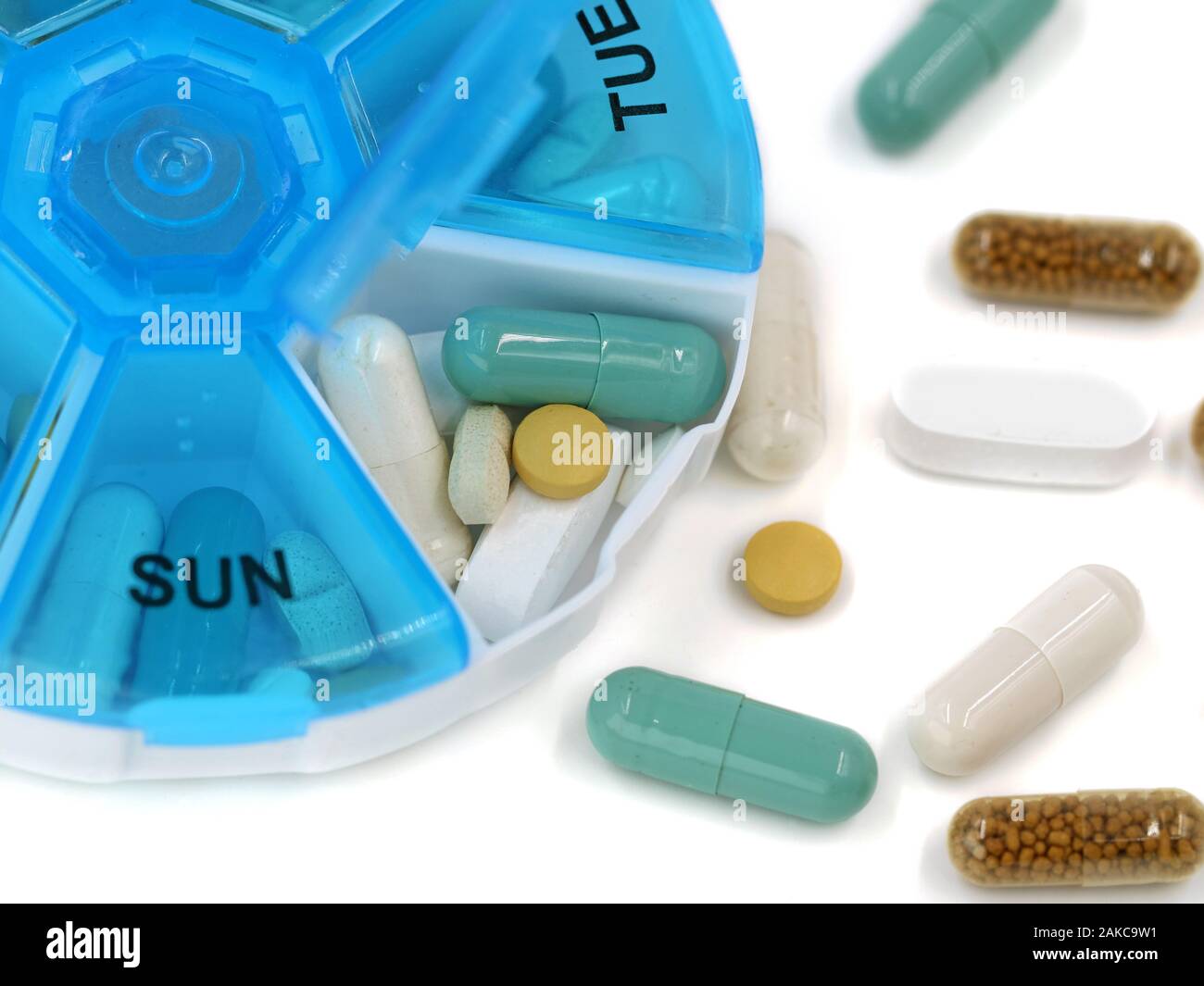 Close up of various pills in daily pill box on white background with copy space Stock Photo
