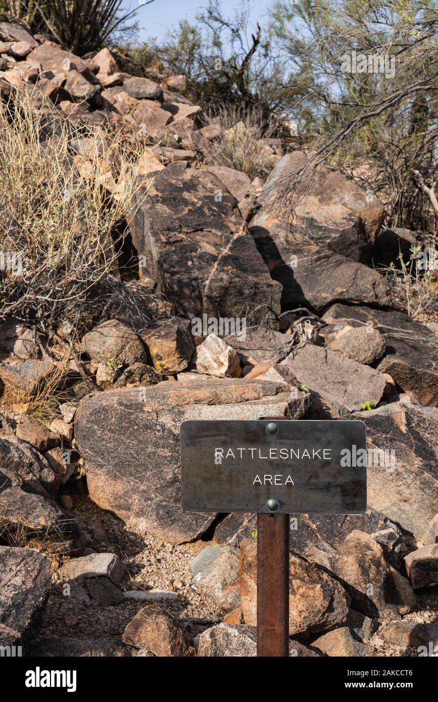 sign along a rocky hiking path that says rattlesnake area Stock Photo