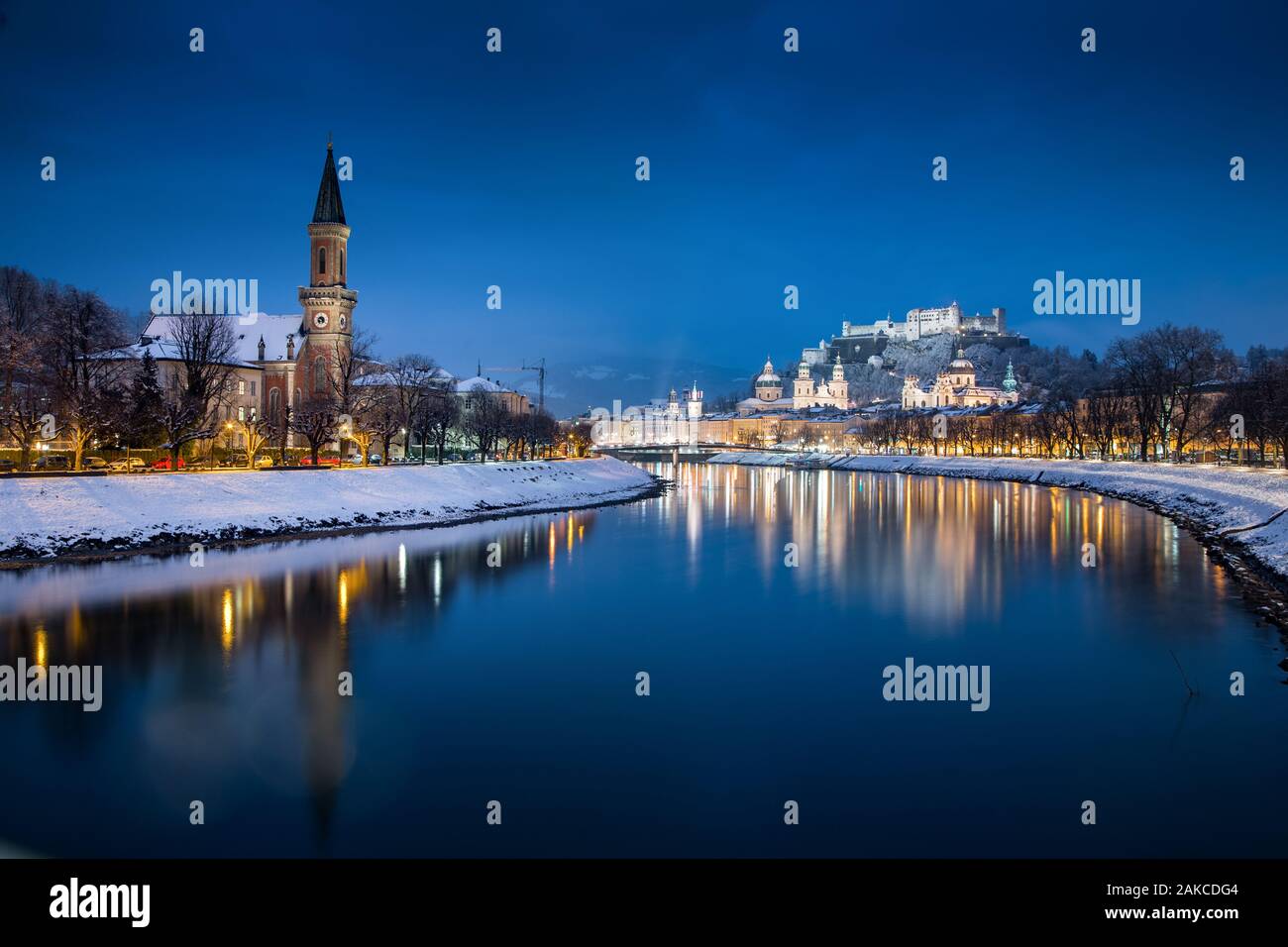 Classic view of the historic city of Salzburg with famous Festung Hohensalzburg and Salzach river illuminated in beautiful twilight during scenic Chri Stock Photo