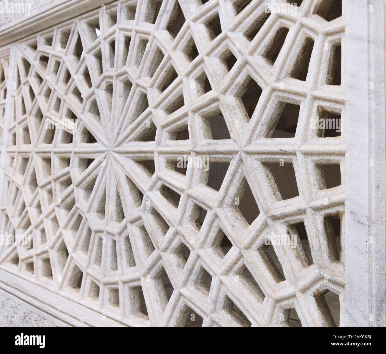 Close up of Islamic stone pattern architectural element resembling dharma wheel of Buddhism. Stock Photo