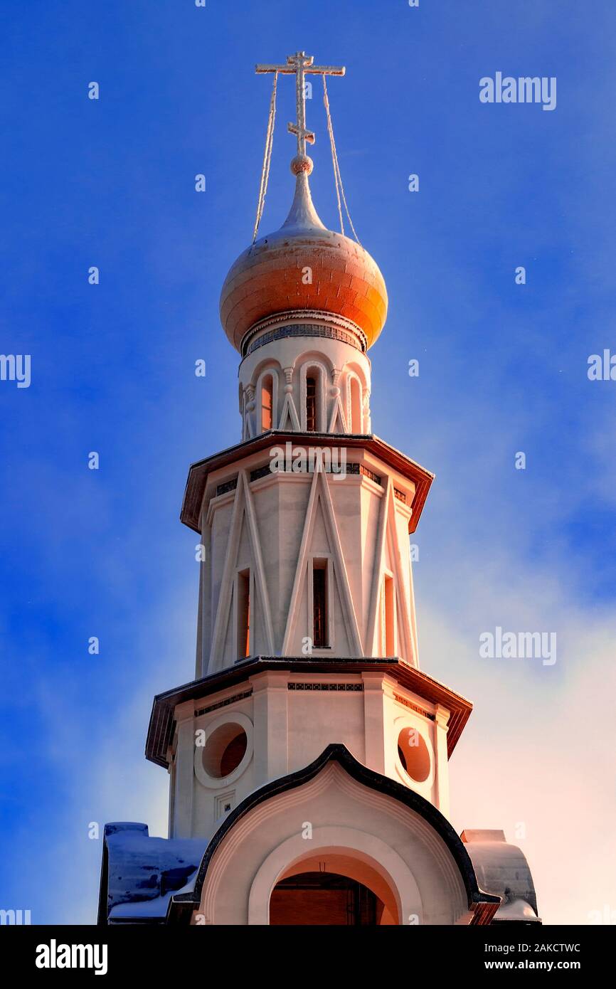 Bell tower of Orthodox Church in Russia against blue sky. View from front below. Stock Photo