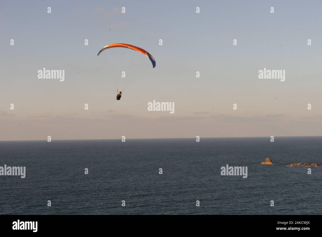 A man is paragliding at the beach of Legzira in the upwinds from the cliff Stock Photo