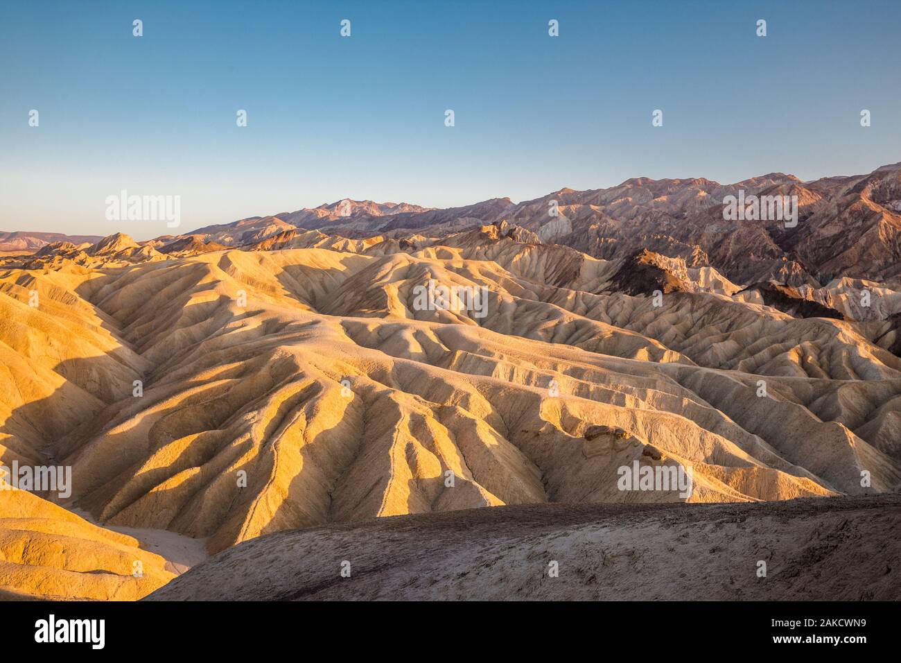 Scenic view of sandstone formations at famous Zabriskie Point viewpoint in beautiful golden evening light at sunset, Death Valley National Park, USA Stock Photo