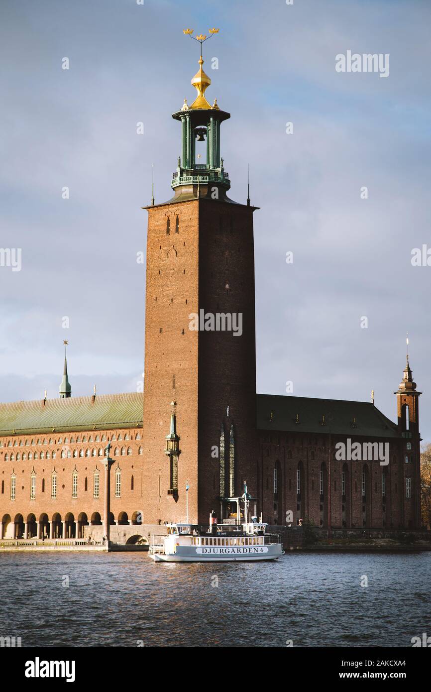 Scenic view of famous Stockholm city hall with Djurgarden ferry boat at sunset, central Stockholm, Sweden, Scandinavia Stock Photo