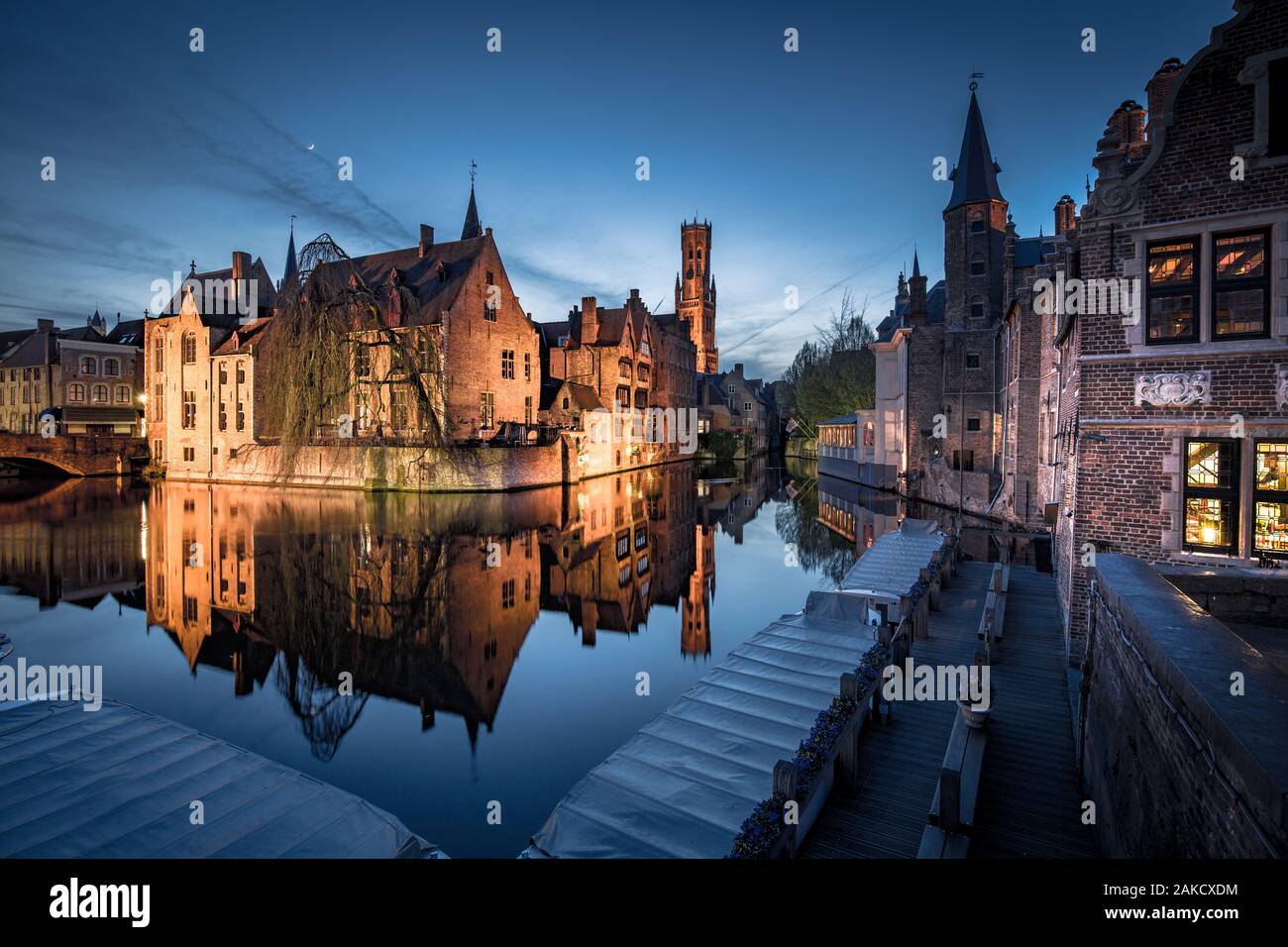 Classic postcard view of the historic city center of Brugge, often referred to as The Venice of the North, with famous Rozenhoedkaai illuminated in be Stock Photo