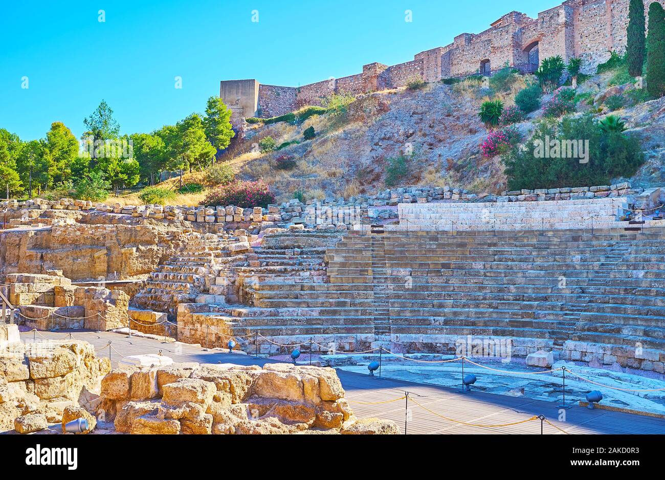 The antique ruins of Teatro Romano (Roman Amphitheater), located at the foot of the hill, occupied with ramparts of Alcazaba Malaga fortress, Andalusi Stock Photo