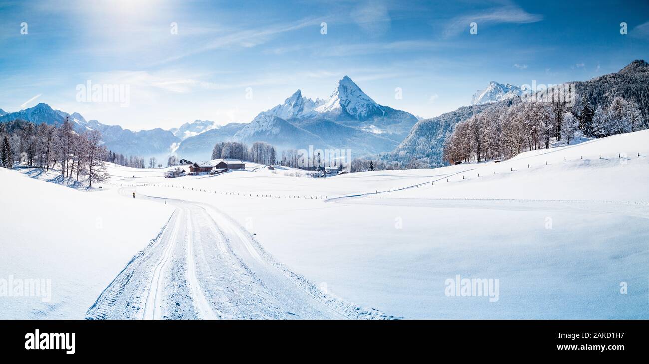 Scenic winter wonderland mountain scenery in the Alps with cross-country skiing track on a cold sunny day with blue sky and clouds Stock Photo