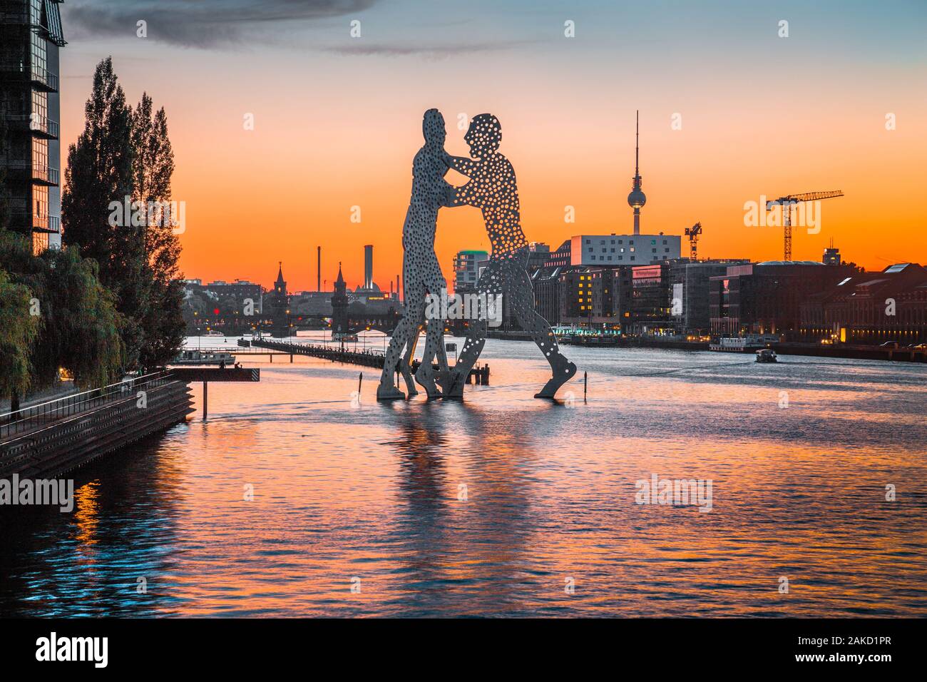 Panoramic view of Berlin skyline with famous Molecule Man sculpture and Spree river in beautiful post sunset twilight at dusk in summer Stock Photo