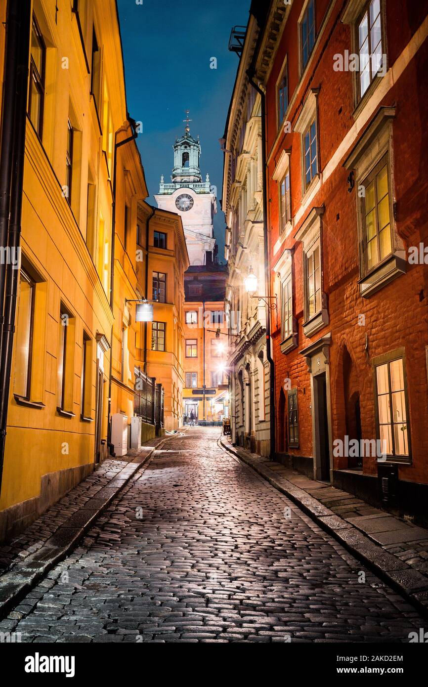 Classic twilight view of tradtional houses in beautiful alleyway in Stockholm's historic Gamla Stan (Old Town) illuminated during blue hour at dusk Stock Photo