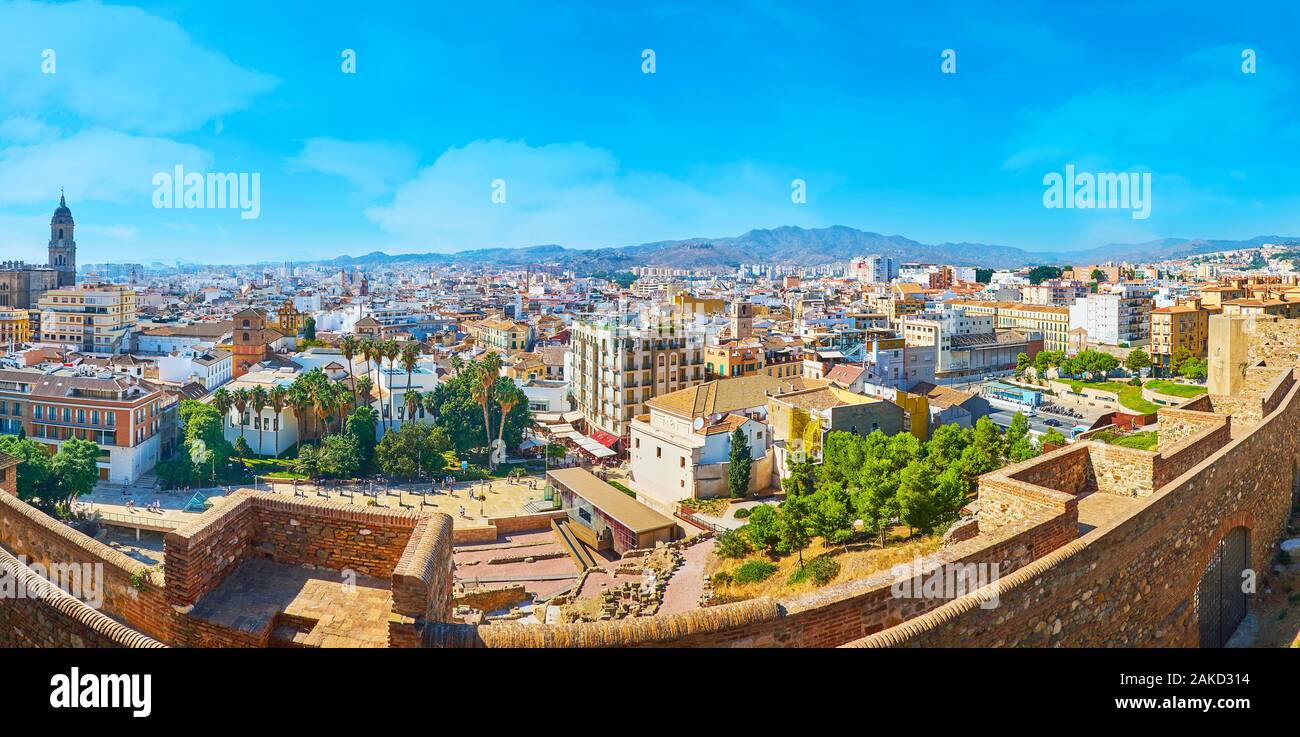 MALAGA, SPAIN - SEPTEMBER 26, 2019: Panorama of Malaga, surrounded by mountains, with medieval Alcazaba ramparts on the foreground and old town distri Stock Photo