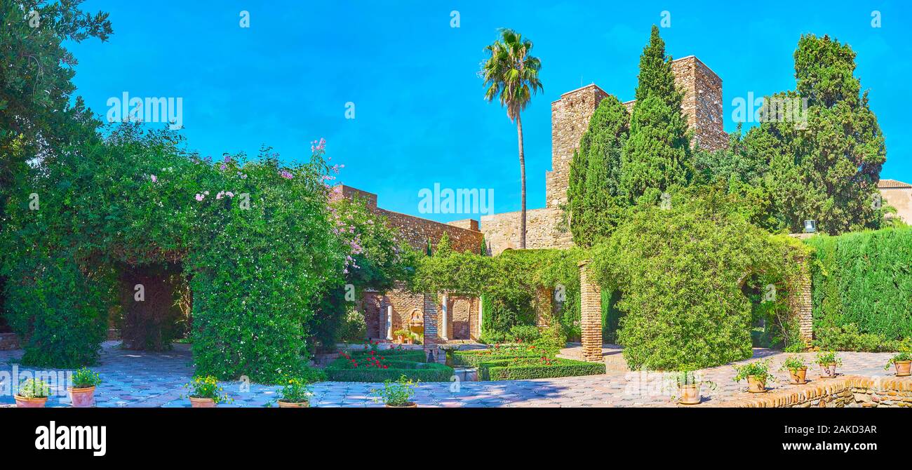 Panorama of Patio de la Surtidores (Terrace of Water Jets), decorated with lush green plants, topiary bushes, flowers and small fountains, Malaga, Spa Stock Photo