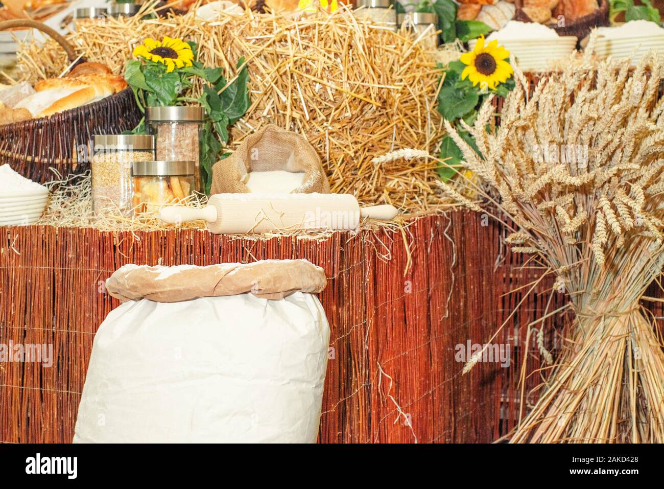 A variety of bakery products made from wheat flour.Spikelets of spinous wheat next to the dishes . Baking bread concept.Wheat flour in bags next to wh Stock Photo
